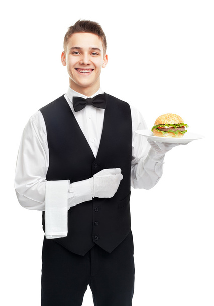 Young smiling waiter holding hamburger on plate - Foto, Imagen