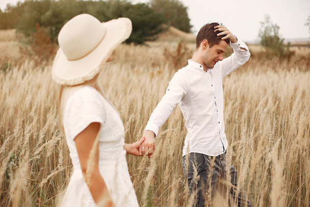 Beautiful couple spend time in a autumn field - 写真・画像