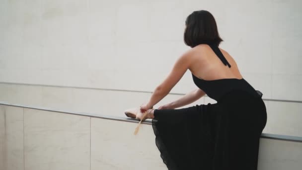 young professional ballerina in black dress is dancing outdoors - Video