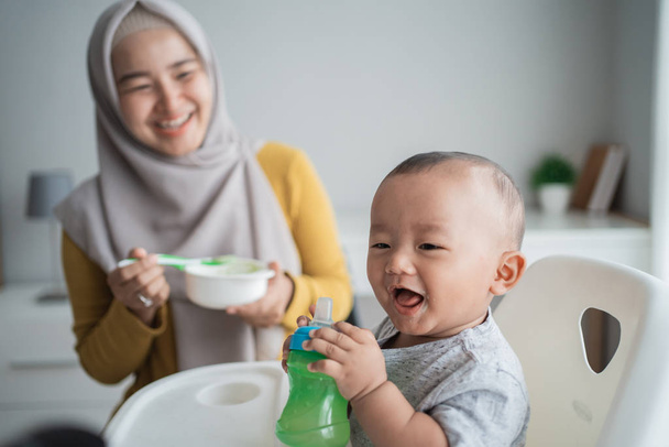 asian child eating solid food from mother - Photo, image