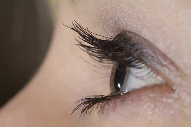 close-up of a woman's eye with a black background - Φωτογραφία, εικόνα