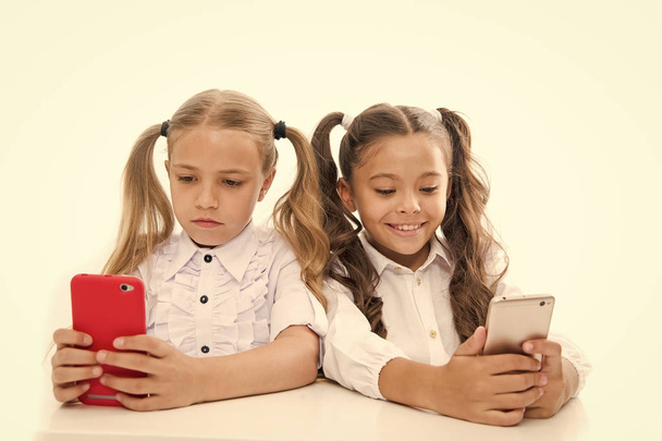 The future is mobile. Little girls using smartphones isolated on white. Small kids having video lesson on mobile phones. Preparing students for future life. Future career with digital skills. Future - Valokuva, kuva
