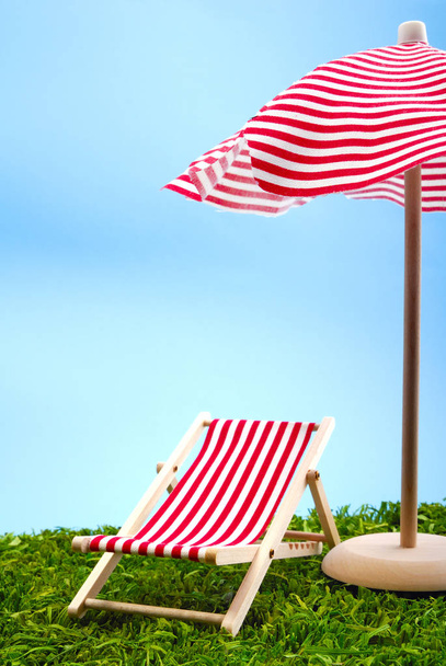 red umbrella and striped chairs on the beach - Foto, Imagem