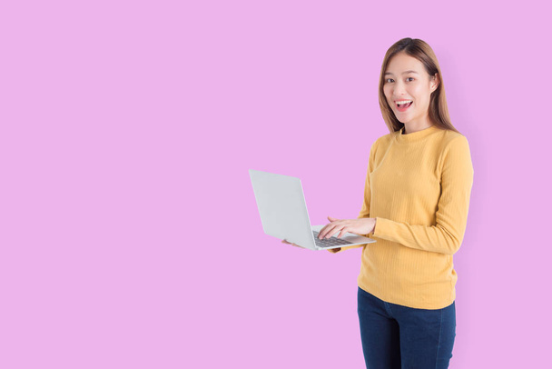 美しい若いアジアの女性がノートPCと笑顔を保持 - 写真・画像