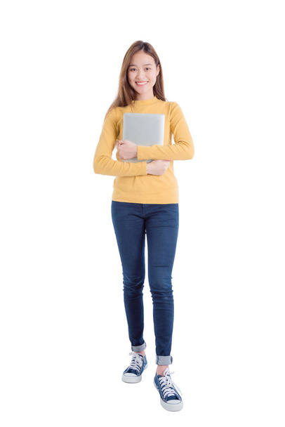 Full length of young asian beautiful girl holding notebook computer and smiles - Fotoğraf, Görsel