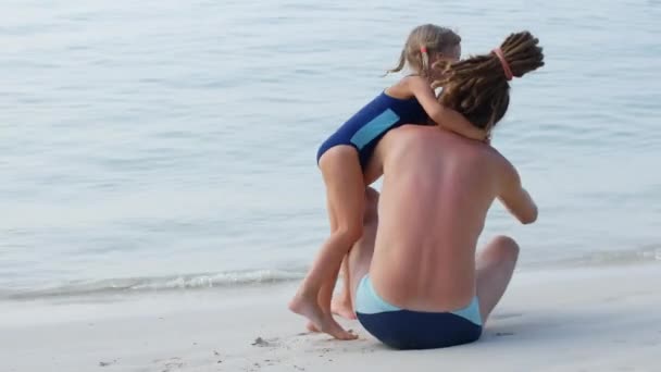 Dad and daughter spend time together and have fun on the beach, family values and care - Felvétel, videó