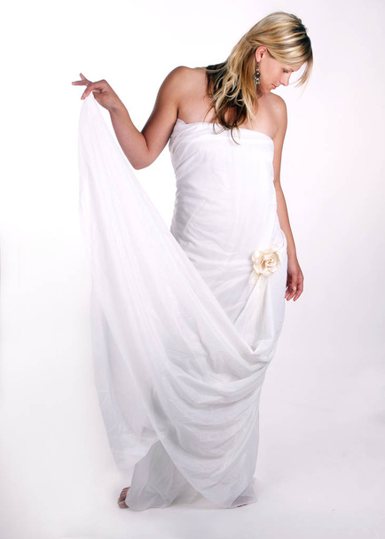 beautiful young woman in white dress posing in studio - Фото, изображение