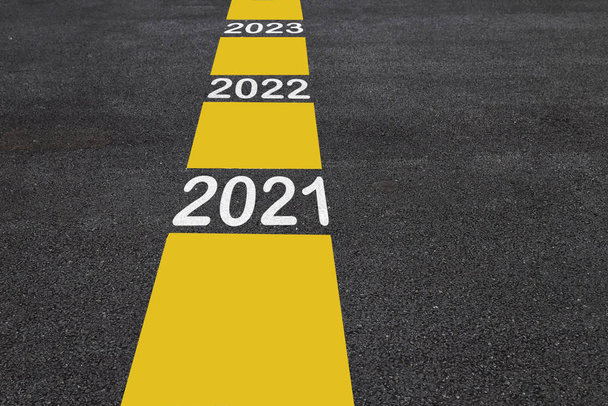 Αριθμός 2021 έως 2023 σε άσφαλτο οδόστρωμα με γραμμές σήμανσης, Καλή Χρονιά έννοια - Φωτογραφία, εικόνα