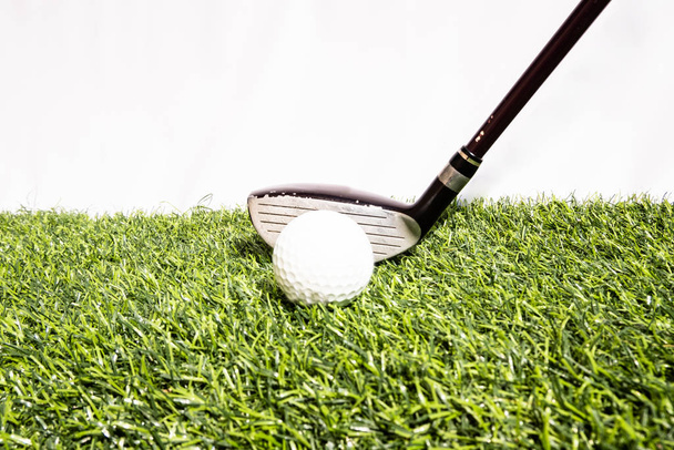 Клуб для гольфа, в котором играют люди, бьющие мячом для гольфа по искусственной траве. Зеленый означает быть готовым к игре в гольф
 - Фото, изображение