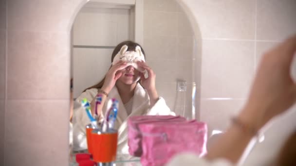 Mladá žena si sundá masku na spaní v koupelně - Záběry, video
