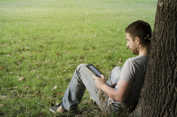 Junger Mann liest E-Book - Foto, Bild