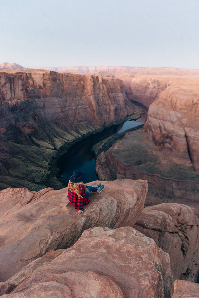 blondýny dívka sedí Podkova ohyb v Glen Canyon národní rekreační oblasti v časném svítání - Fotografie, Obrázek