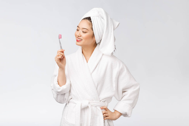 aziatische gelukkig vrouw met tandenborstel in badjas ochtend stemming - Foto, afbeelding