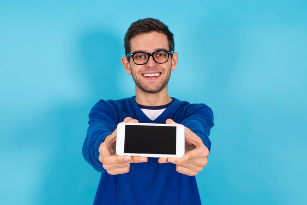 hombre hipster joven casual con teléfono móvil aislado en el fondo de color
 - Foto, Imagen