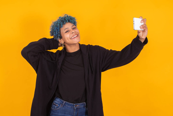trendy color woman making photo with mobile phone isolated on yellow background - Photo, Image