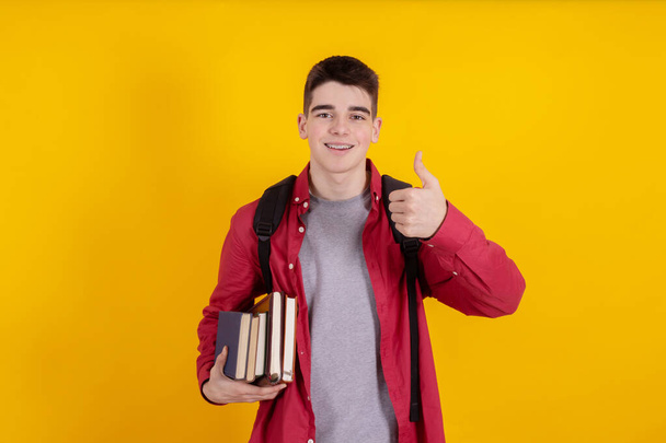 teenage student with books and school or university backpack isolated on color background - Photo, Image