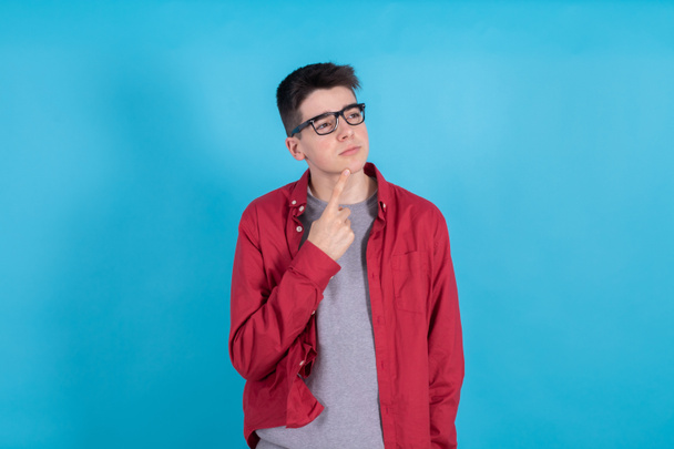 mladý dospívající muž myšlení izolované na barevném pozadí - Fotografie, Obrázek