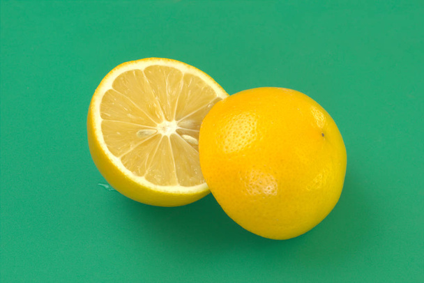 Fruta limón. Cítricos frescos en rodajas sobre fondo verde. Primer plano de fruta jugosa amarilla. Fuente natural de vitamina C
. - Foto, imagen