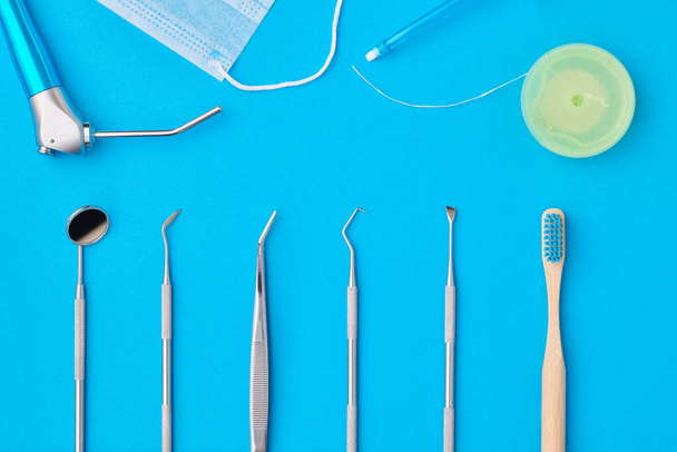 Herramientas dentistas sobre fondo azul vista superior
 - Foto, Imagen