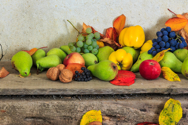 autumnal still life with fruit and leaves on a wooden base - Foto, imagen