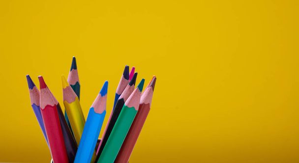 Colored pencils on yellow background. Copy space - Zdjęcie, obraz
