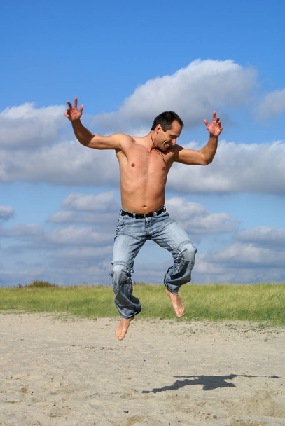 young man jumping on the beach - Фото, зображення