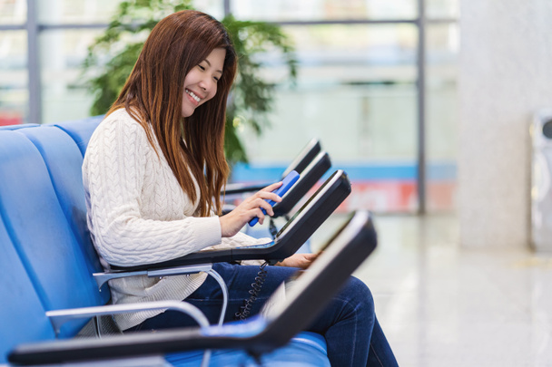 Passagier in het bezit en scannen van mobiele telefoon met qr code scanner machine van bericht stoel in de luchthaven, Technologie met reizen en toerist, check-in self-service, vervoer concept, - Foto, afbeelding