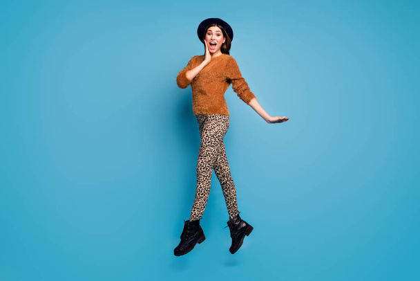 Full length photo of cheerful astonished girl jump look incredible bargains discount scream wow omg impressed jump wear stylish autumn spring style outfit isolated over blue color background - Fotó, kép