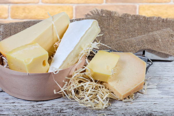 Различные сорта сыра на старой деревянной поверхности
 - Фото, изображение