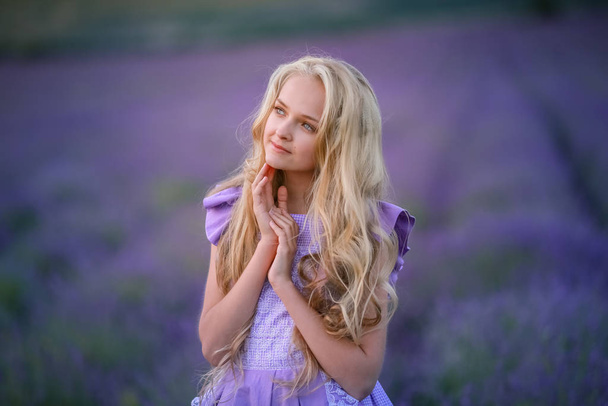 Portrait of a beautiful adult girl with long hair on the background of lavender field - Fotografie, Obrázek