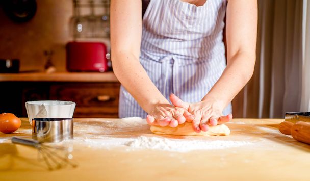 fingers on dough, chef kneads dough for baking, concept cooking, bakery - Fotó, kép