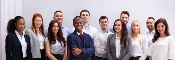Group Of Young Successful Multi-ethnic Young Office Workers Standing Looking At Camera - 写真・画像