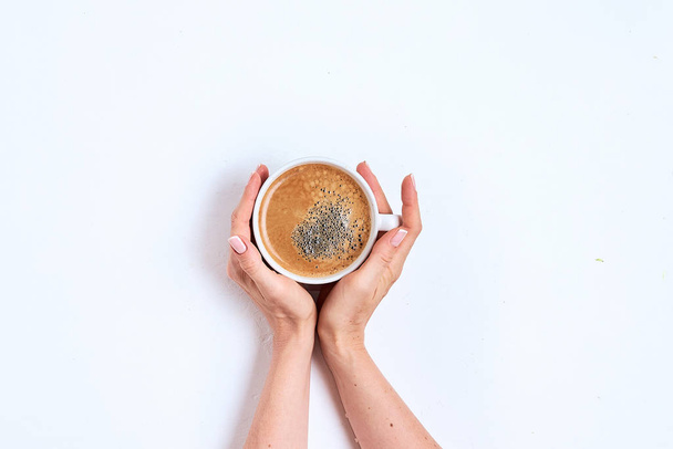 Female hand hold coffee cup on wood table. Top view - Foto, Imagen
