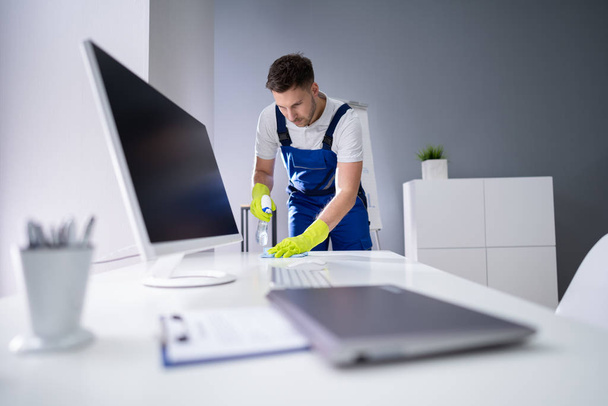 Portrait Of Happy Young Maid Cleaning Glass Table In Office - Foto, Bild