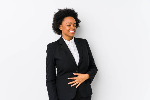 Afrikanische Geschäftsfrau mittleren Alters vor weißem Hintergrund berührt isoliert Bauch, lächelt sanft, Ess- und Zufriedenheitskonzept. - Foto, Bild