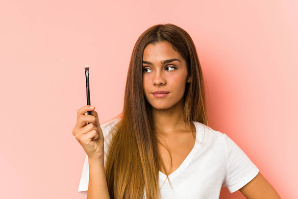 Young caucasian woman holding a eyebrush isolated - Foto, afbeelding