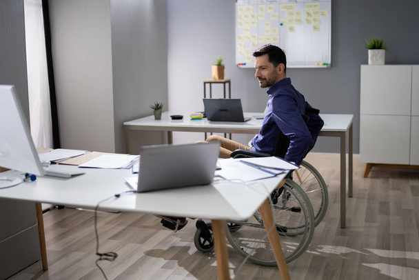 Close-up Of Businessman Sitting On Wheelchair In Office - Foto, Imagen