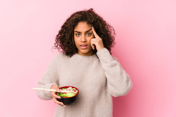 Fiatal afro-amerikai nő eszik tészta mutatja csalódottság gesztus mutatva mutatóujj. - Fotó, kép