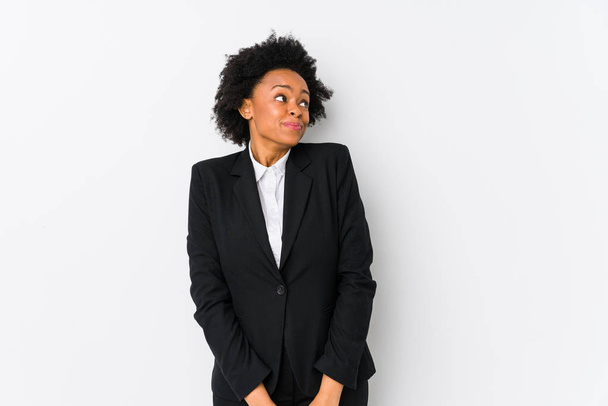 Mulher de negócios afro-americana de meia-idade contra um fundo branco isolado sonhando em alcançar objetivos e propósitos
 - Foto, Imagem