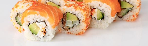 finom Philadelphia és California sushi lazaccal és masago kaviárral fehér alapon, panorámás felvétel - Fotó, kép