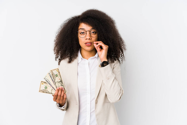 Young afro business woman holding a credit car isolated Young afro business woman holding a credit carwith fingers on lips keeping a secret. - Foto, immagini
