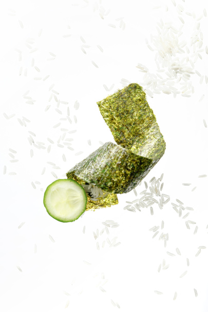 top view of nori seaweed piece, cucumber slice and rice isolated on white - Photo, Image