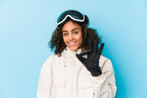 Young african american skier woman isolated cheerful and confident showing ok gesture. - Фото, изображение