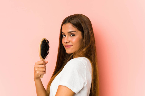 Jeune femme caucasienne tenant une brosse à cheveux isolé
 - Photo, image