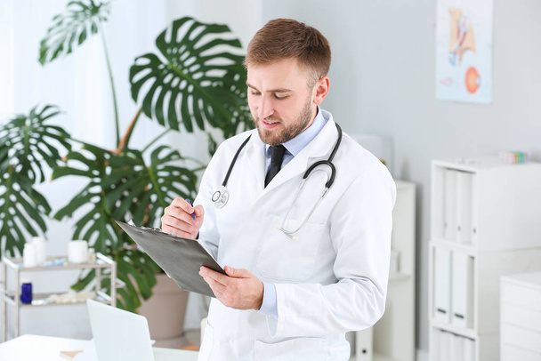 Portrait of male doctor with clipboard in clinic - Foto, immagini