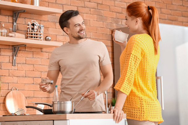 Happy couple cooking together in kitchen - Photo, Image