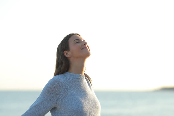 Happy girl breaths fresh air on the beach - Fotó, kép