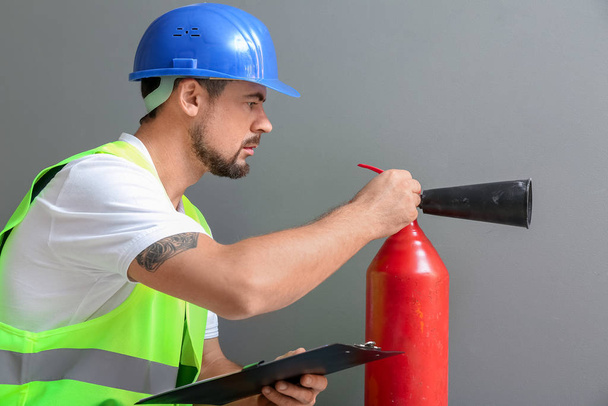 Fire safety specialist inspecting extinguisher - Photo, Image