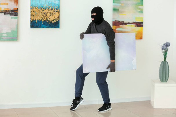 Κλέφτης κλέβοντας φωτογραφία από γκαλερί τέχνης - Φωτογραφία, εικόνα
