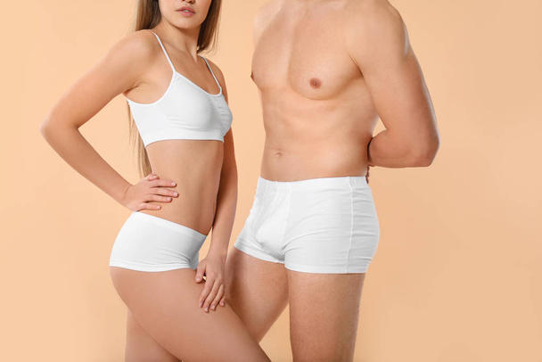 Young couple in underwear on color background - Φωτογραφία, εικόνα